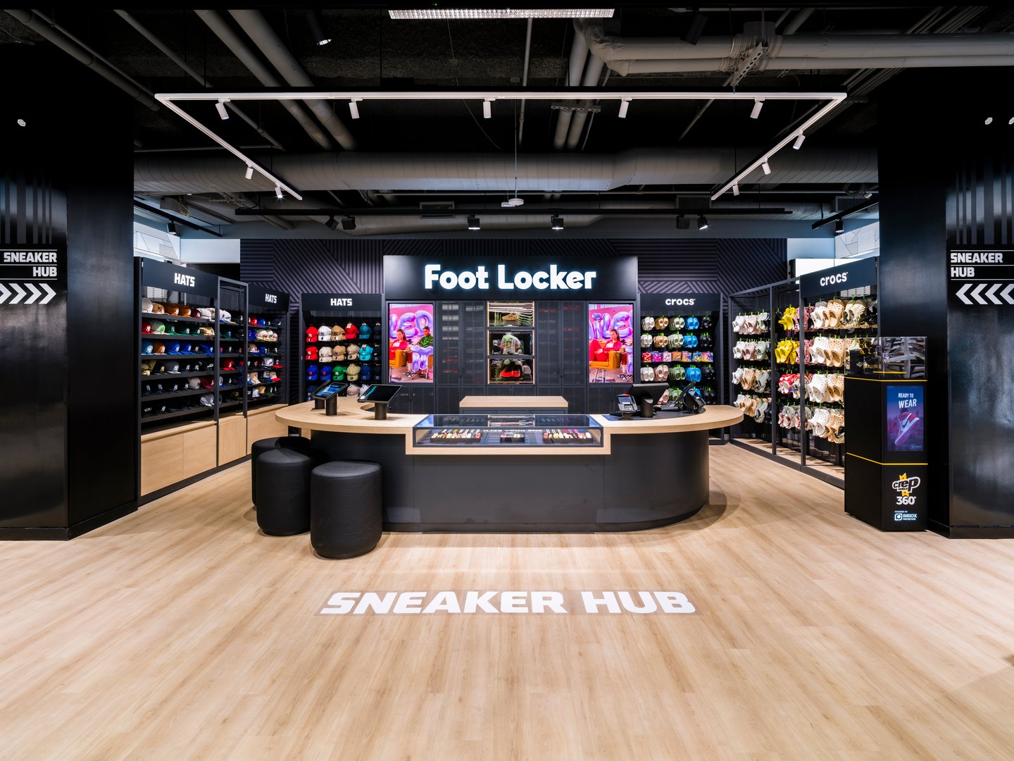 In-store merchandising wall with curated athletic footwear and apparel